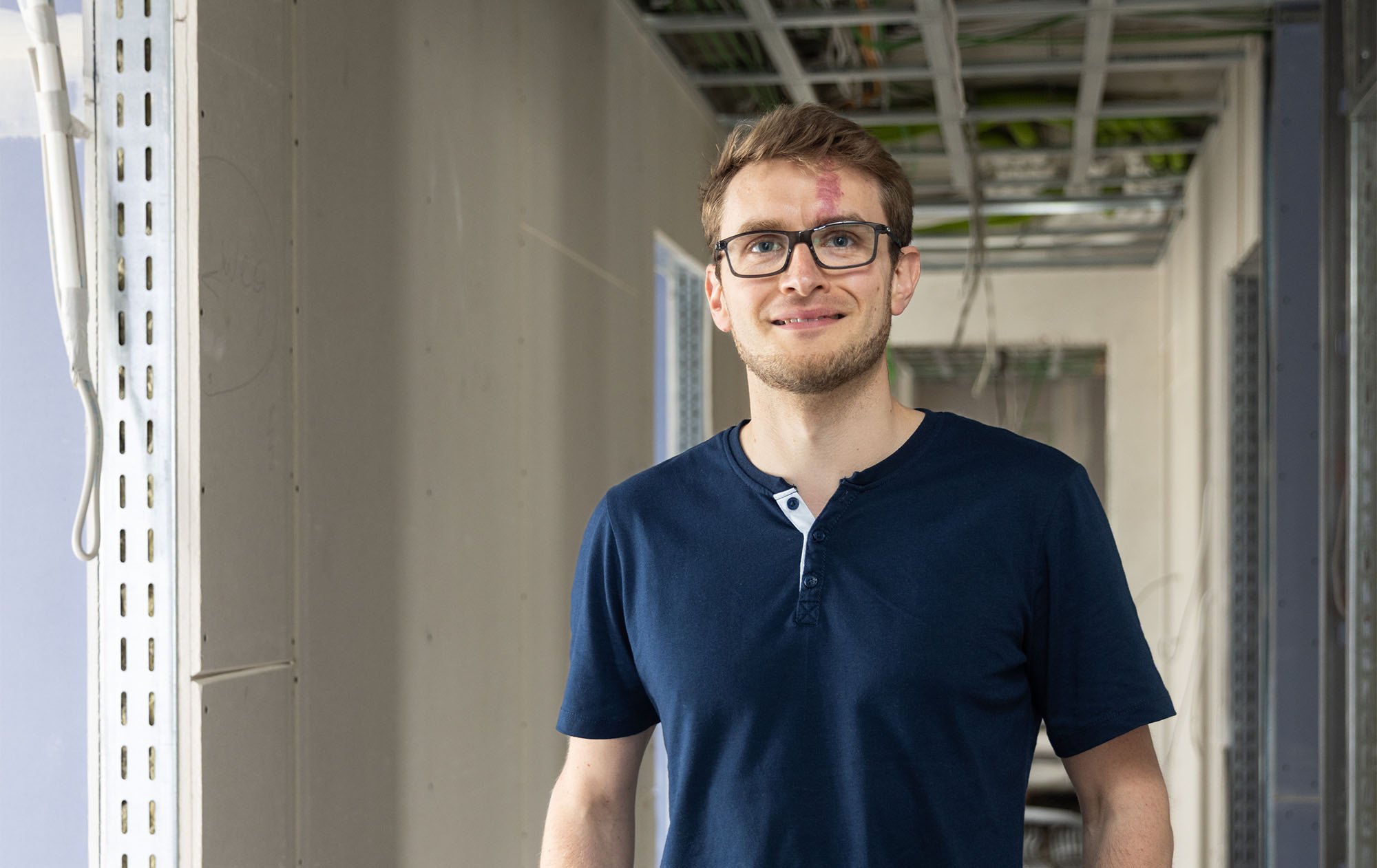 Joseph Schwanitz in seiner Zahnarztpraxis noch im Bau. Er trägt eine Brille und blaues Polohemd.